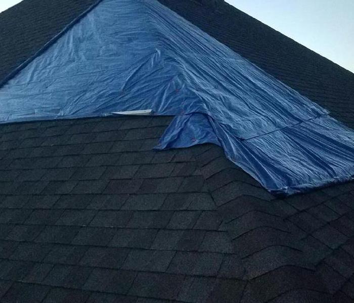 Damaged part of roof covered in tarp