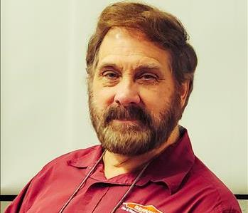 man with short hair and a beard looking at camera